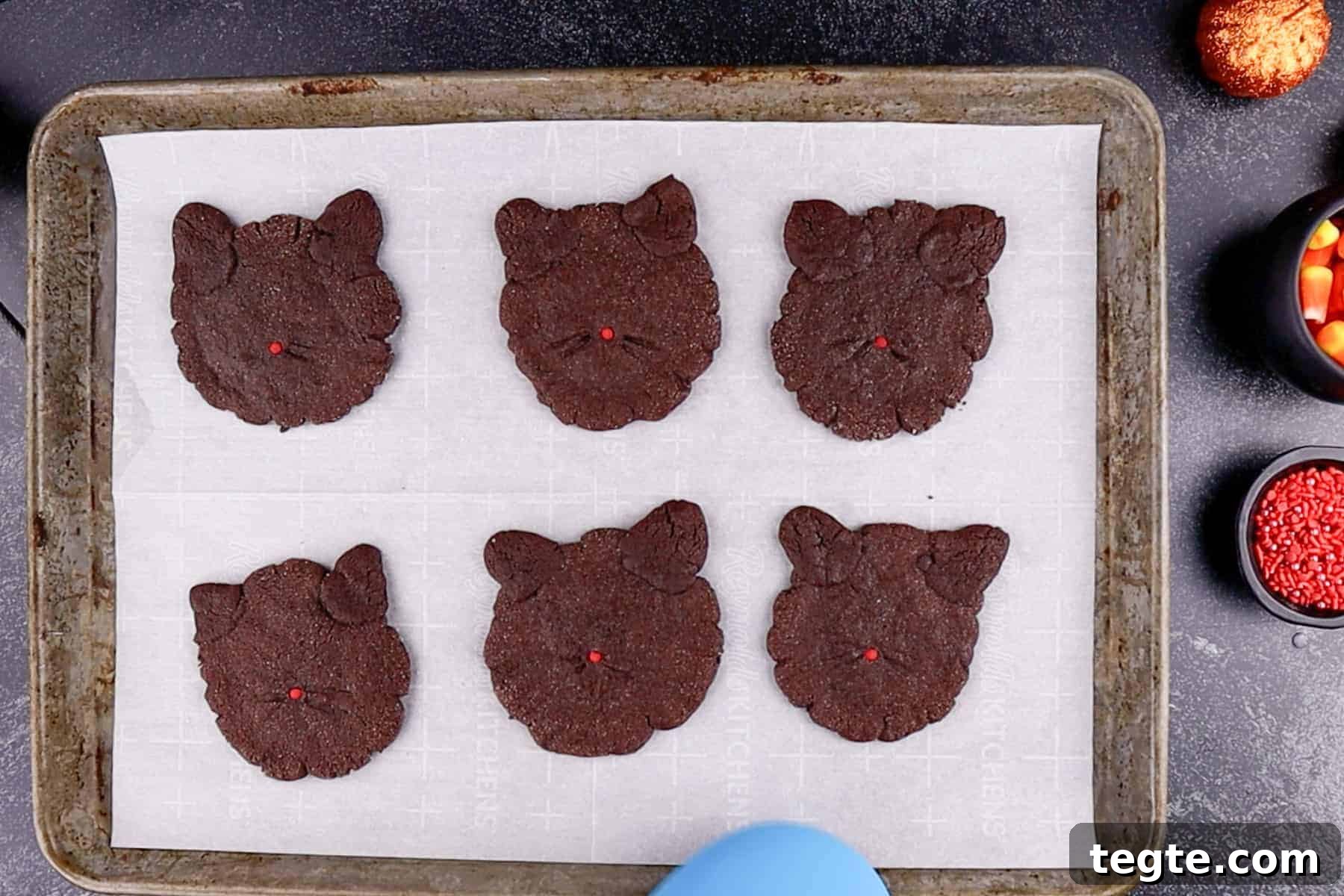 Black Cat Cookie Recipe: Soft Chocolate Drops for Halloween 11 Baked black cat cookies on parchment-lined cookie tray.
