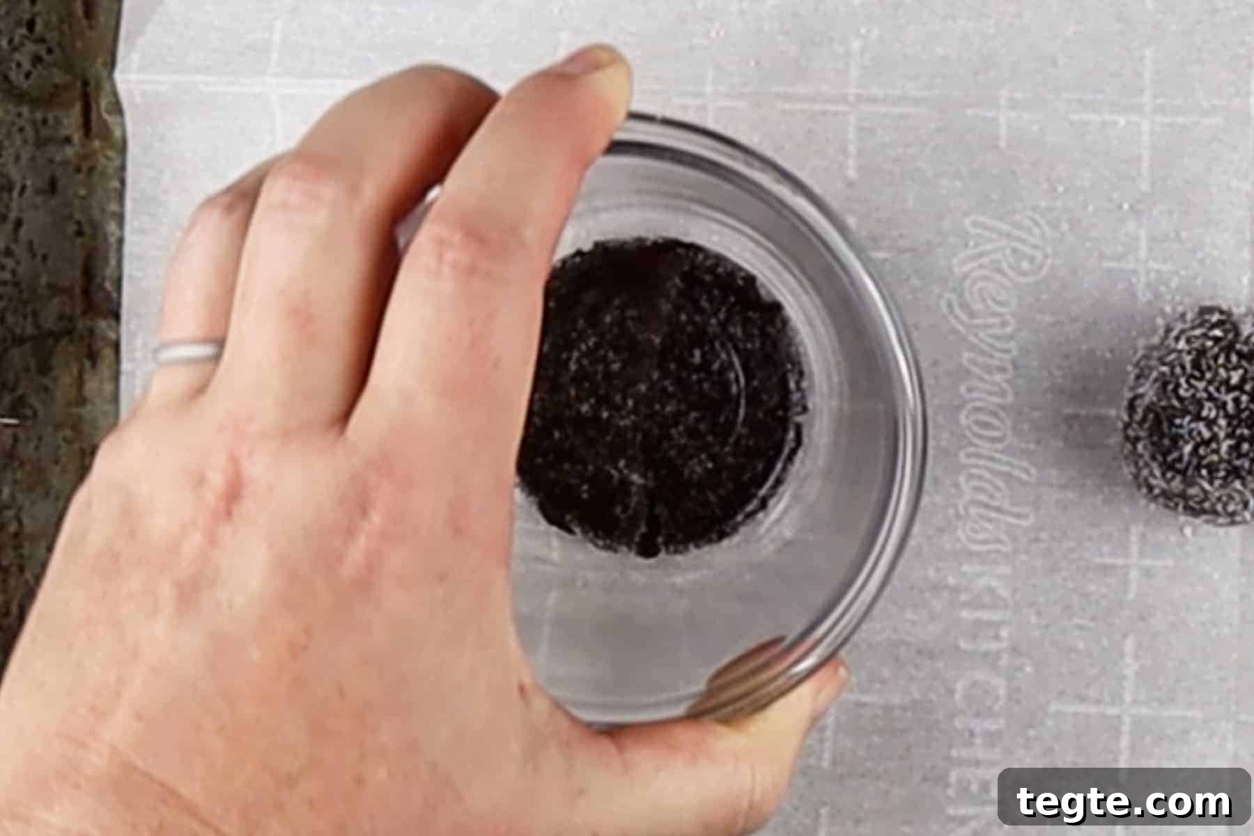 Black Cat Cookie Recipe: Soft Chocolate Drops for Halloween 8 Flattening rolled cookie dough balls with the bottom of small bowl.