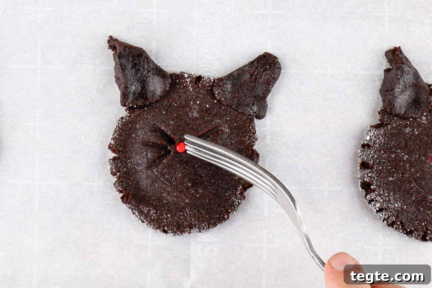 Black Cat Cookie Recipe: Soft Chocolate Drops for Halloween 10 Making whisker indents with a fork on a flattened cookie dough round.