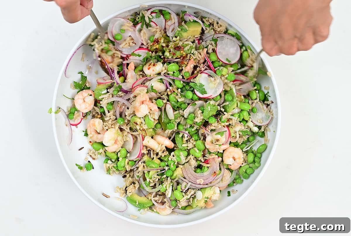 Tossing prawn salad ingredients in a large white bowl