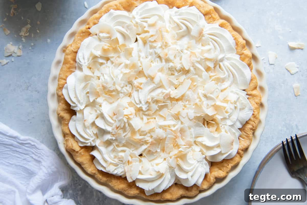 overhead view of a whole coconut cream pie with whipped topping