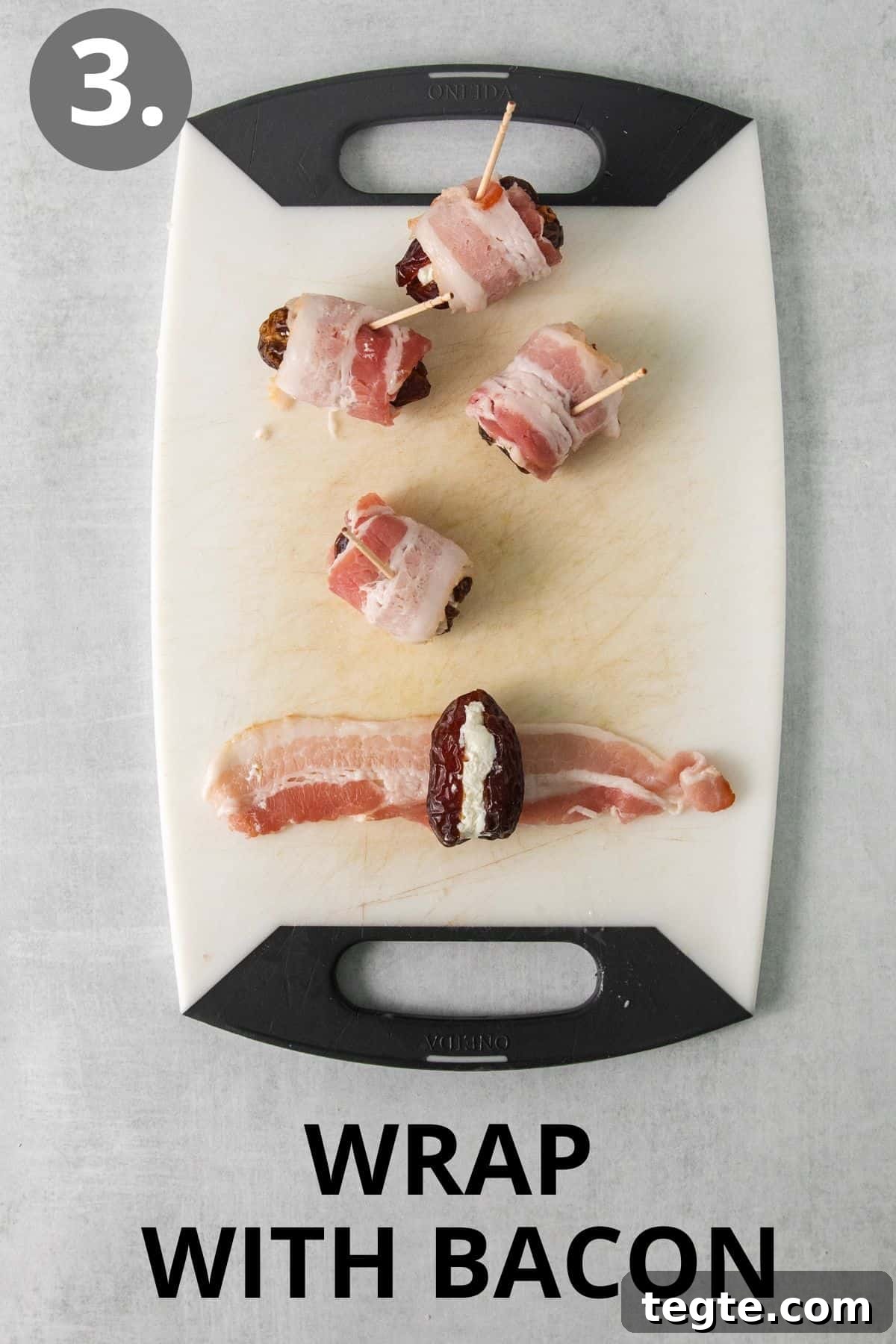 Cheese-filled dates being wrapped with raw bacon on a cutting board