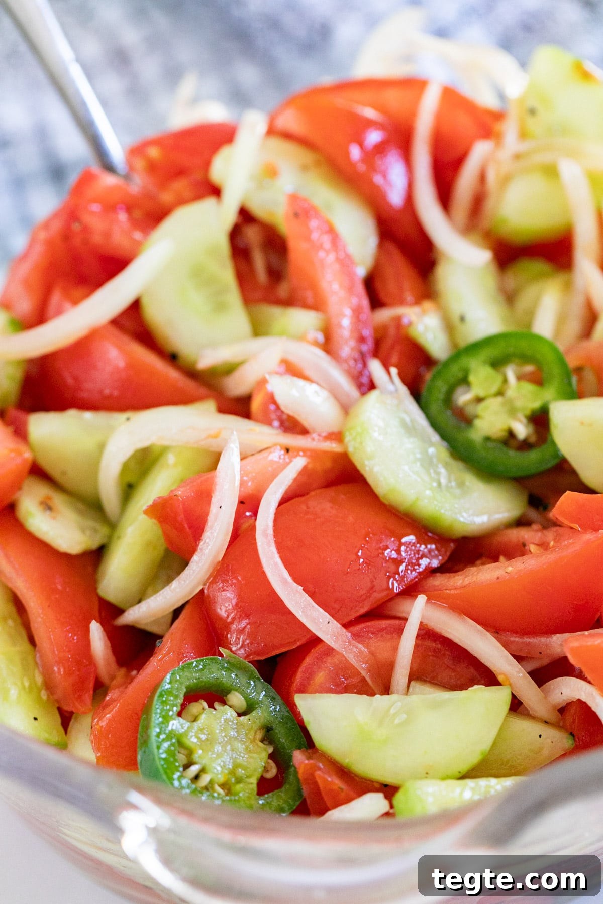 A close up shot of a glass dish with Italian tomato salad.