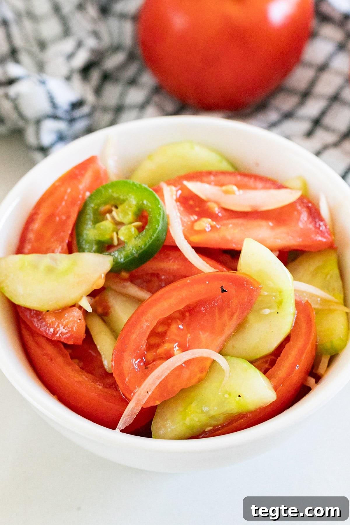 A close up image of a bowl of cucumber tomato salad.