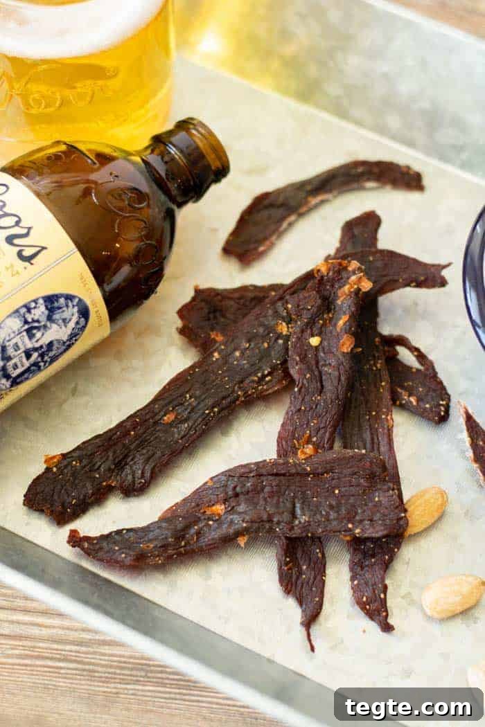 Drunken Spiced Venison Jerky Recipe 2 Deer jerky on platter with glass of beer and a coors original beer bottle