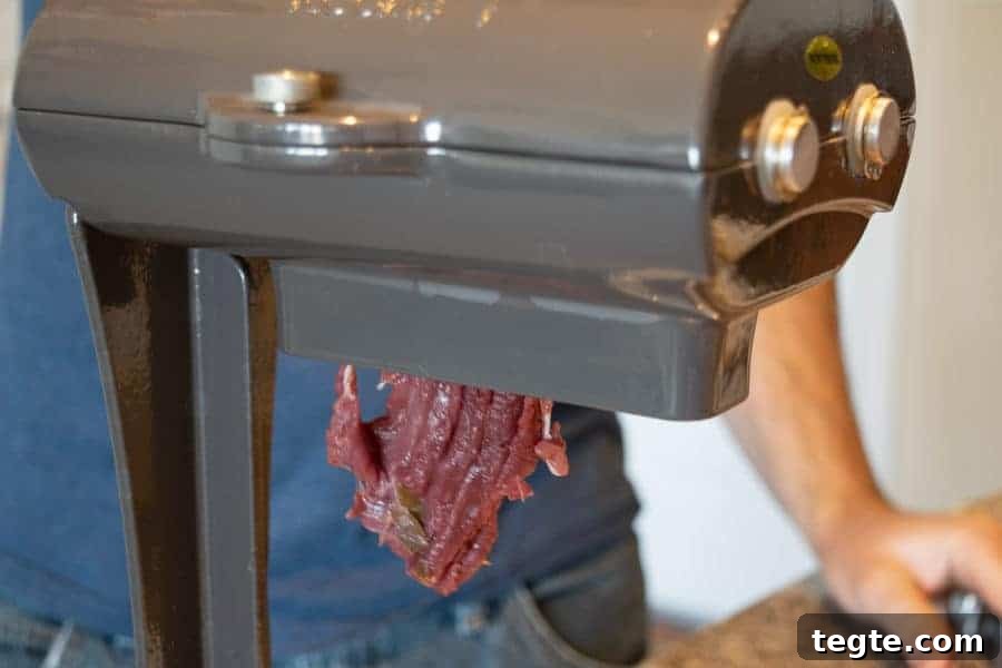 Drunken Spiced Venison Jerky Recipe 6 Venison being sliced by a jerky meat slicer