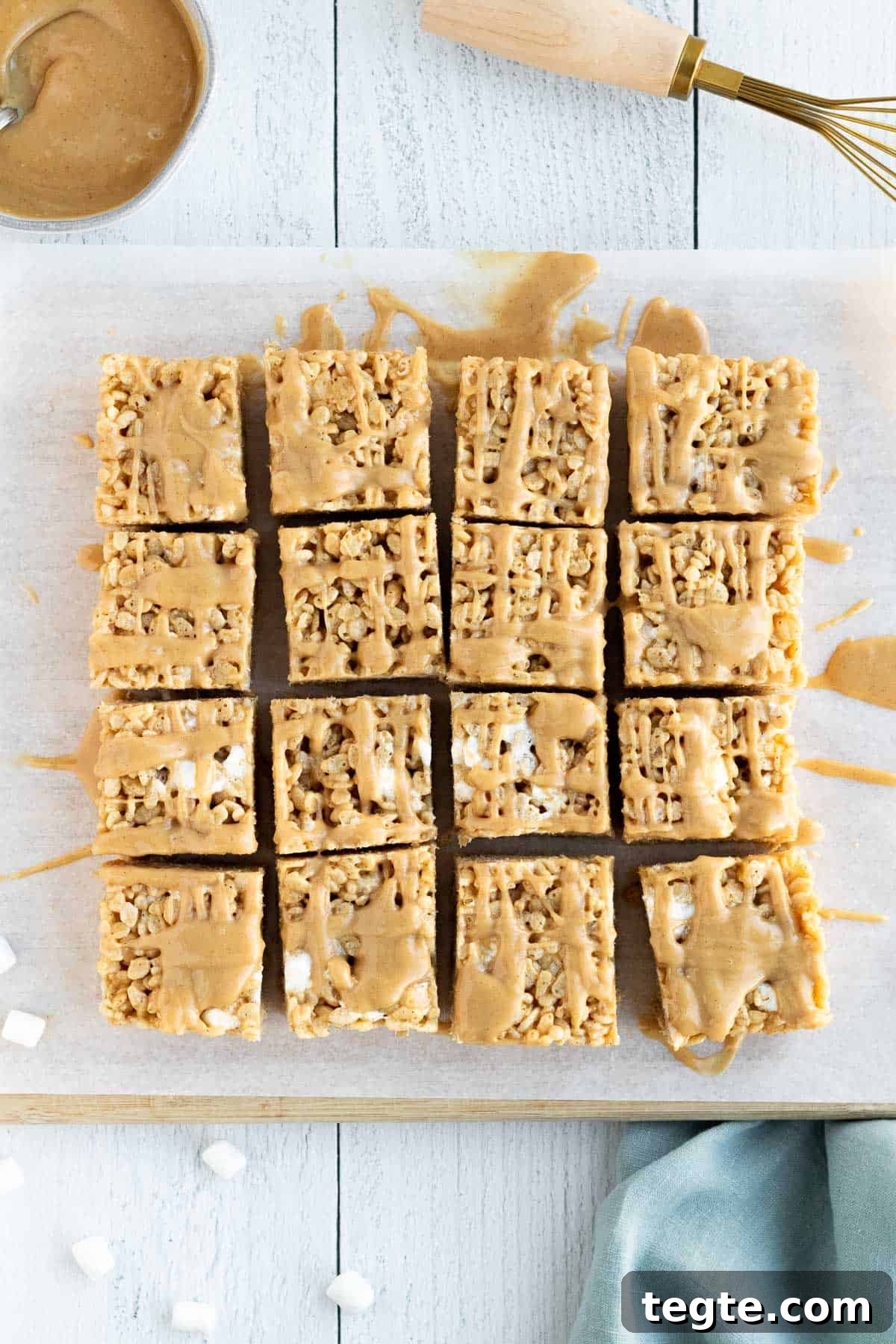 Peanut Butter Rice Krispie Bars Recipe — Crispy No-Bake Treat 2 peanut butter rice krispie bars sliced into squares and sitting on a cutting board