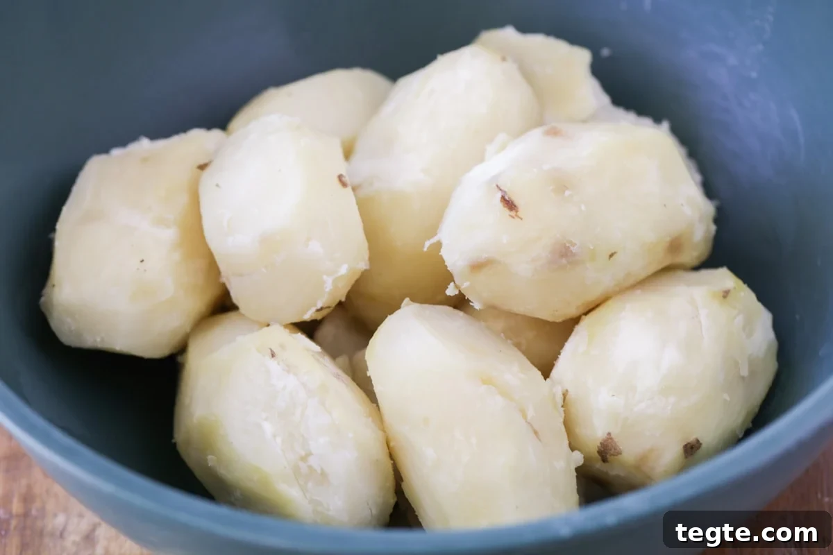 Our family's famous best potato salad recipe is a simple, flavor-packed, and highly requested side dish, perfect for any party! Boiled and peeled potatoes for potato salad.