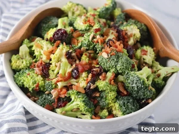 Classic Creamy Potato Salad Recipe for Picnics and BBQs 11 Homemade broccoli salad recipe in white bowl with serving spoons.