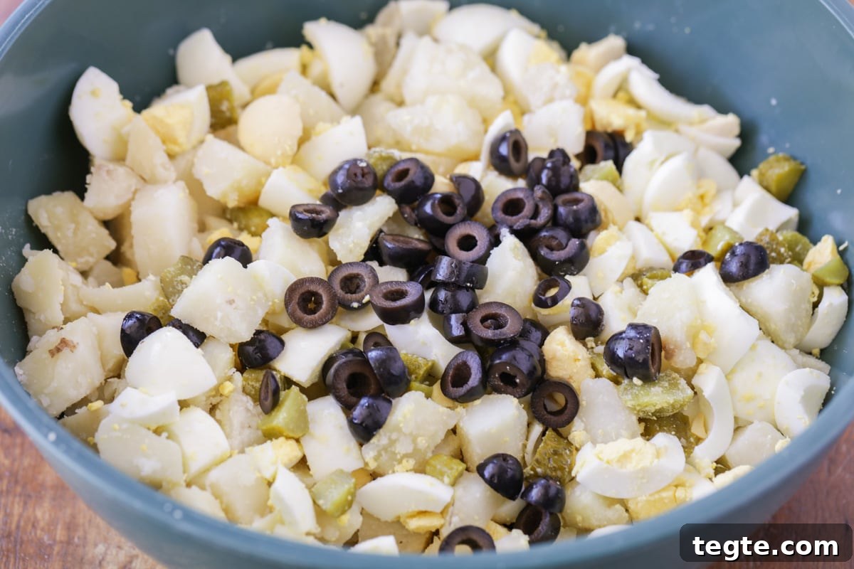 Our family's famous best potato salad recipe is a simple, flavor-packed, and highly requested side dish, perfect for any party! Best potato salad recipe ingredients in a blue bowl.