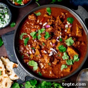 Slow-cooked spicy beef curry in a dish on a dark background