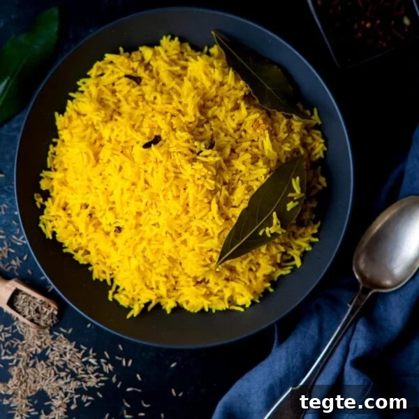 Square image of Pilau rice in a black bowl on a dark surface