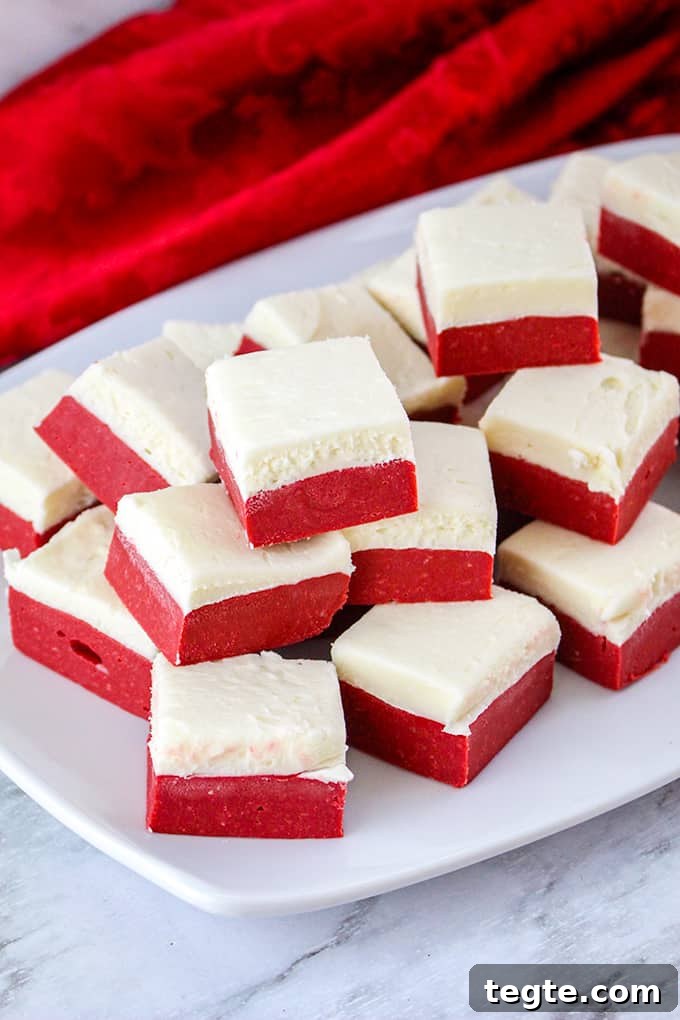 Red Velvet Fudge stacked on a white plate with a red linen on a marble surface