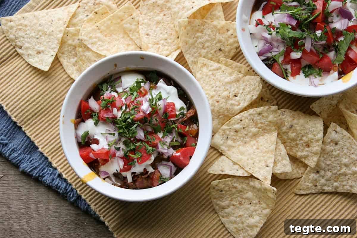 overhead view of 7 layer chili dog dip surrounded by tortilla chips