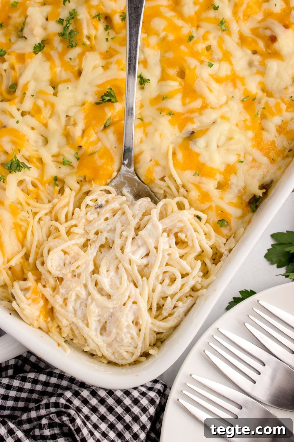 overhead look of chicken tetrazini in a pan with a spoon scooping some up