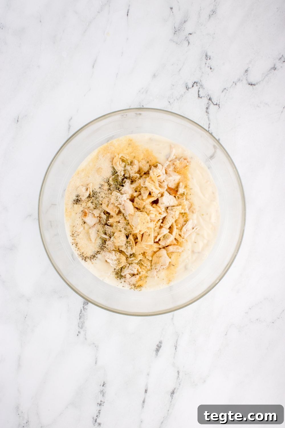 chicken and other ingredients in glass bowl for chicken tetrazzini on table 