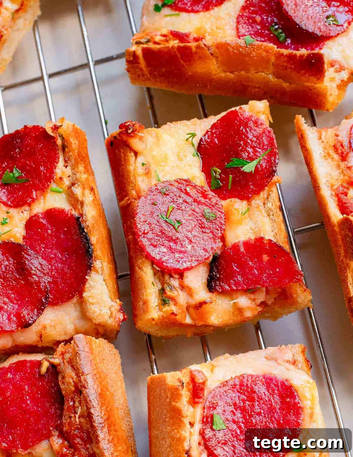 Crispy Garlic Pizza Bread Recipe: Cheesy, Golden & Fast 2 Pepperoni French bread garlic pizza cut into squares on a cooling rack.