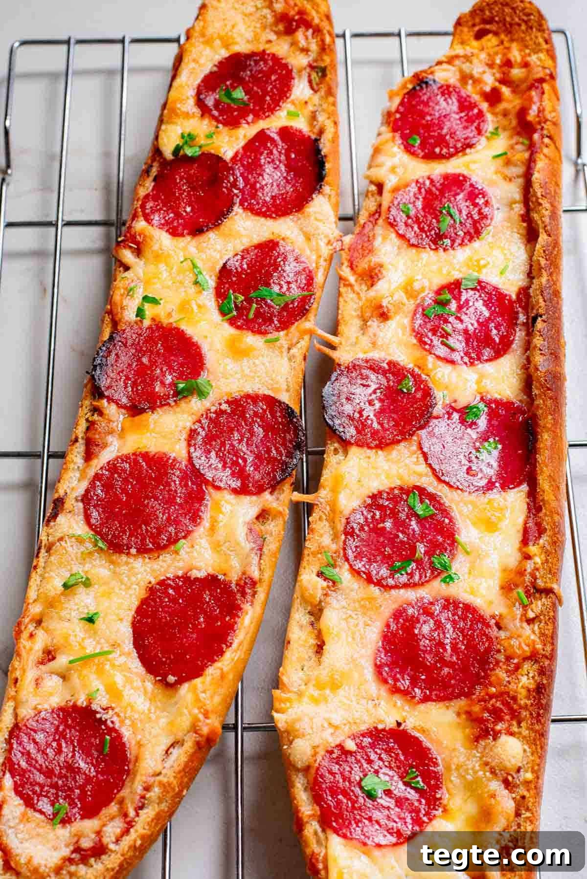 Crispy Garlic Pizza Bread Recipe: Cheesy, Golden & Fast 4 Two slices of pepperoni pizza bread on a cooling rack.