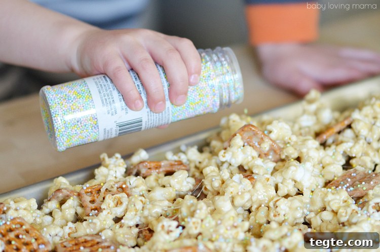 Marshmallow Popcorn Recipe with DIY Spring Treat Bags 4 Adding Sprinkles to Marshmallow Popcorn