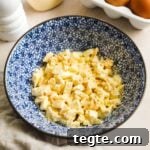 Easy and simple classic egg salad made with Kewpie mayo, salt, pepper, and chopped hard-boiled eggs in a bowl.