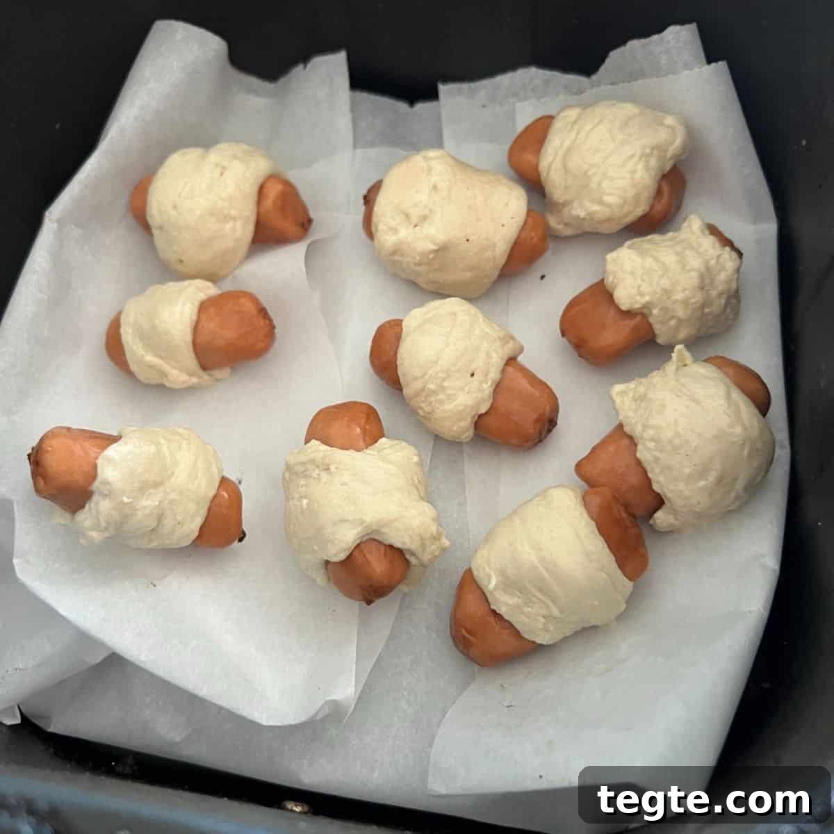 Crispy Air Fryer Pigs in a Blanket Recipe 4 Pigs in a blanket inside air fryer basket.
