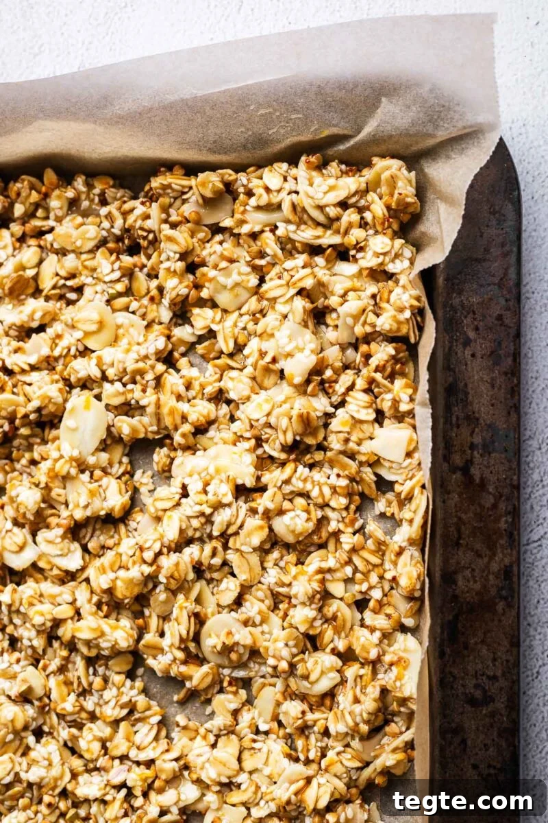 Close-up of unbaked granola mix in a baking tray.