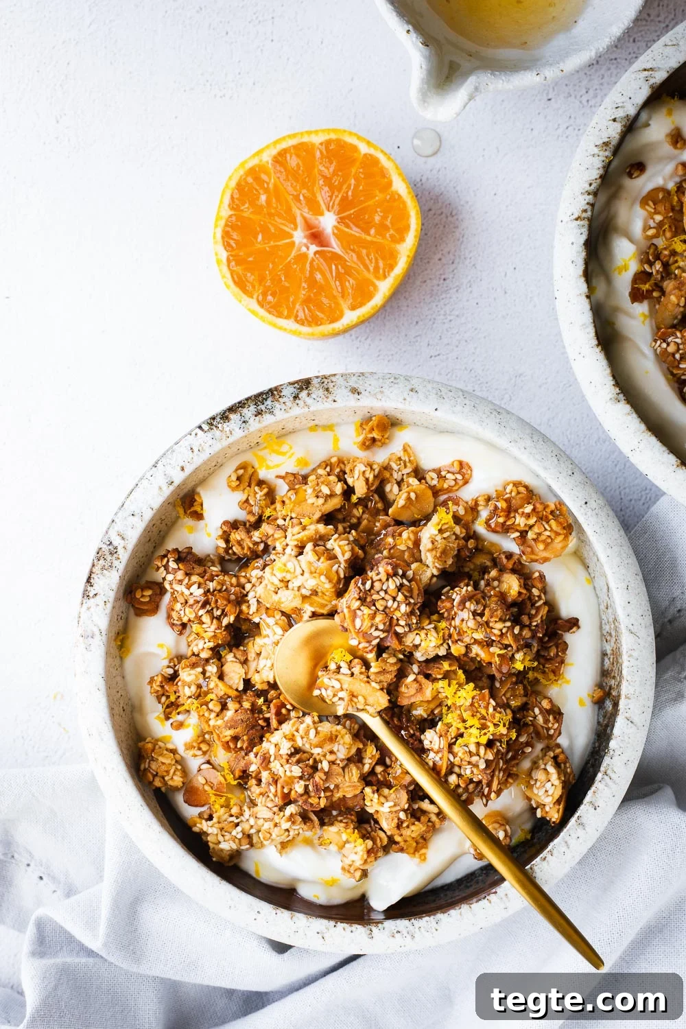 Tahini granola bowls with with yoghurt, orange and honey viewed from top down.