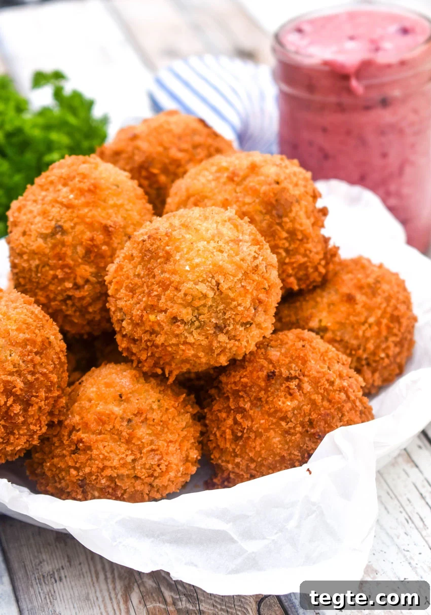 Cornbread Dressing Fritters Recipe: Crispy Southern Side Dish 4 a pile of crispy cornbread dressing fritters on a parchment paper lined bowl