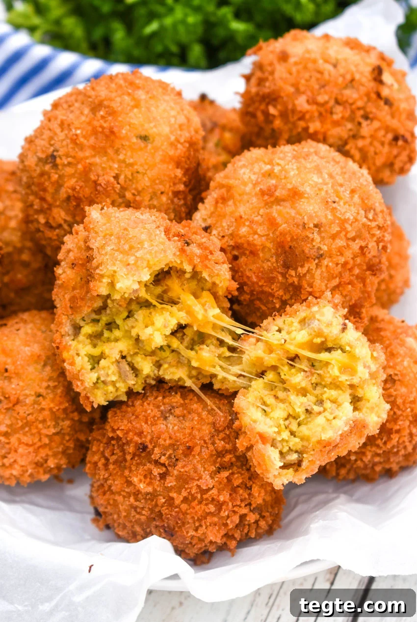 Cornbread Dressing Fritters Recipe: Crispy Southern Side Dish 7 a pile of deep fried cornbread stuffing balls with one torn open to reveal a cheesy center