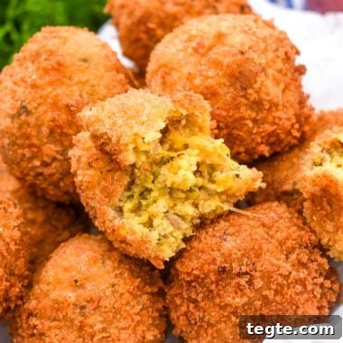 Cornbread Dressing Fritters Recipe: Crispy Southern Side Dish 8 a pile of crispy cornbread dressing fritters on a parchment paper lined bowl