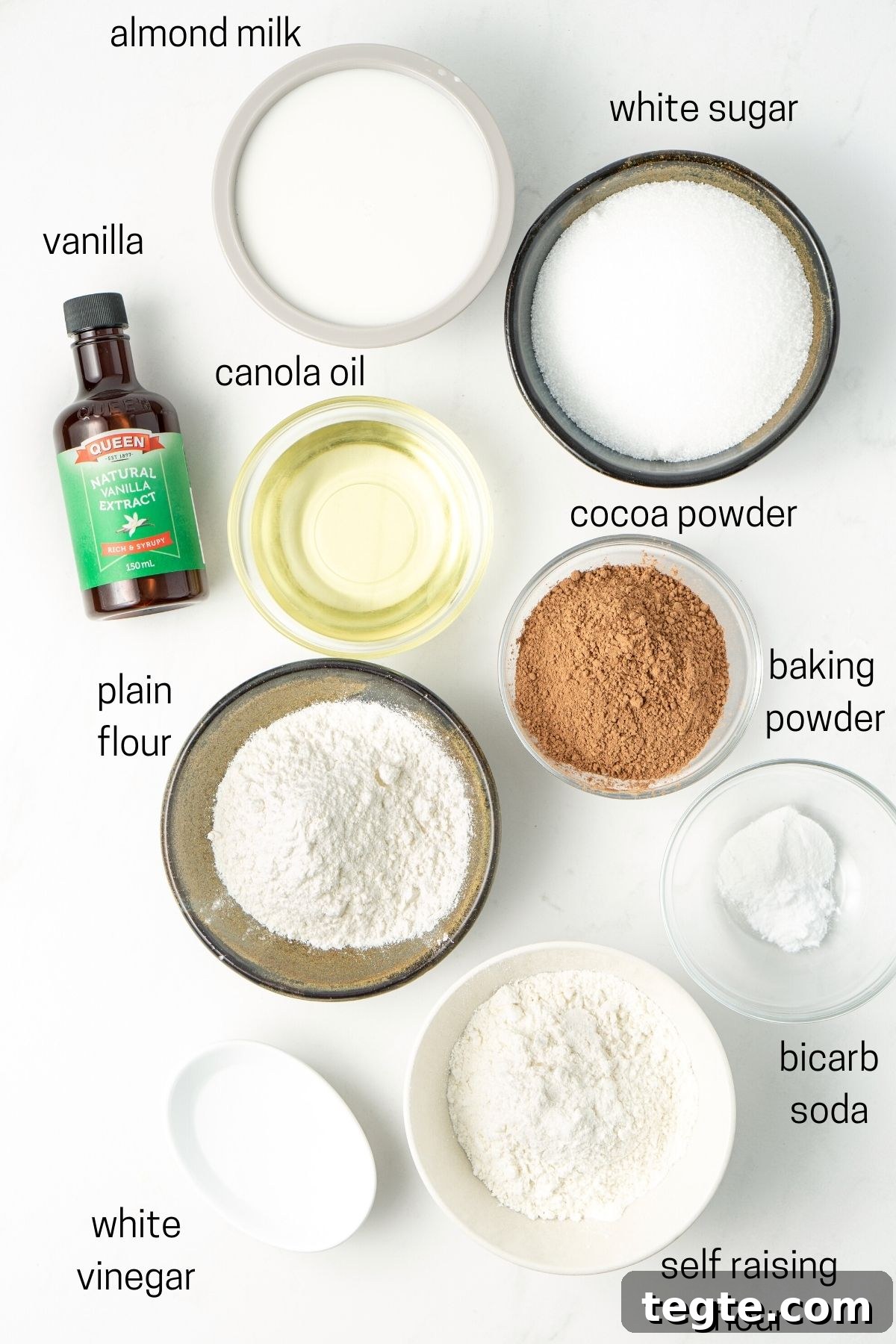 All ingredients for vegan chocolate cupcakes laid out in small bowls. 
