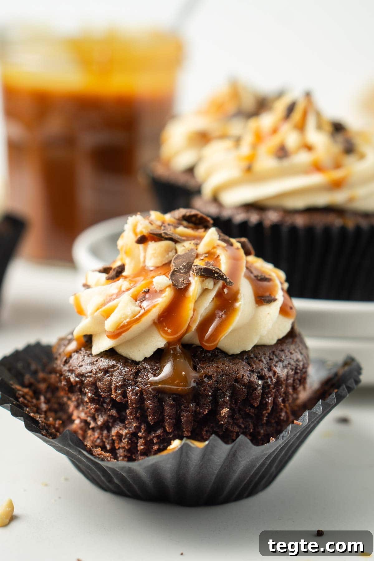 Close up of a single vegan snickers cupcake in a black wrapper.