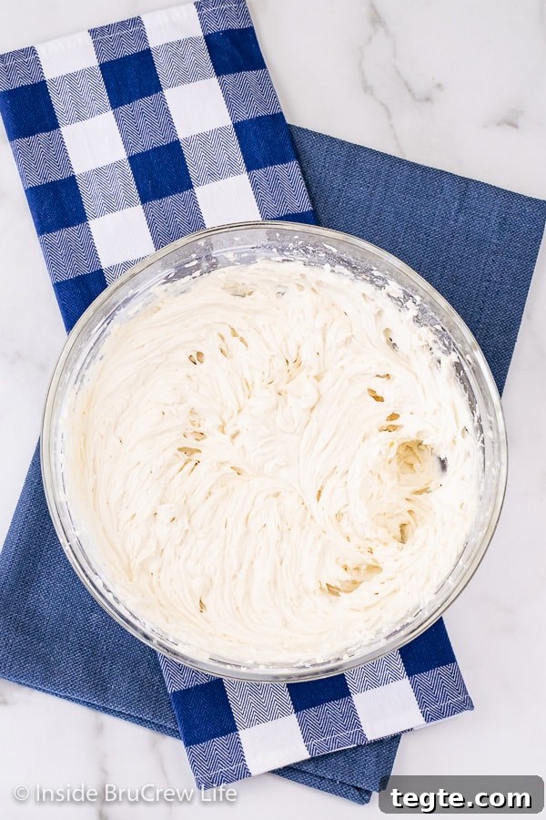 An overhead picture of a large bowl of vanilla buttercream on a blue towel.