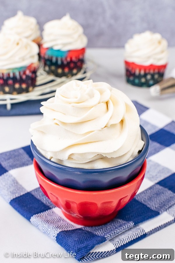 A stack of red and blue bowls filled with a big swirl of vanilla frosting in it.