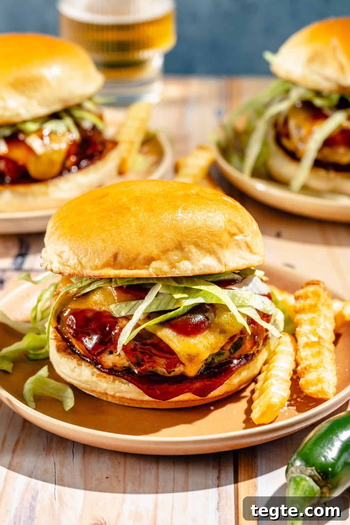 up-close shot of jalapeño cheddar turkey burgers on a plate with french fries