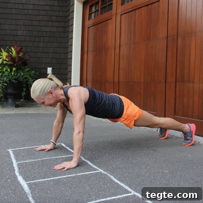 Outdoor Driveway Cardio and Strength Circuit for Women 6 Person doing push-ups on pavement outdoors.
