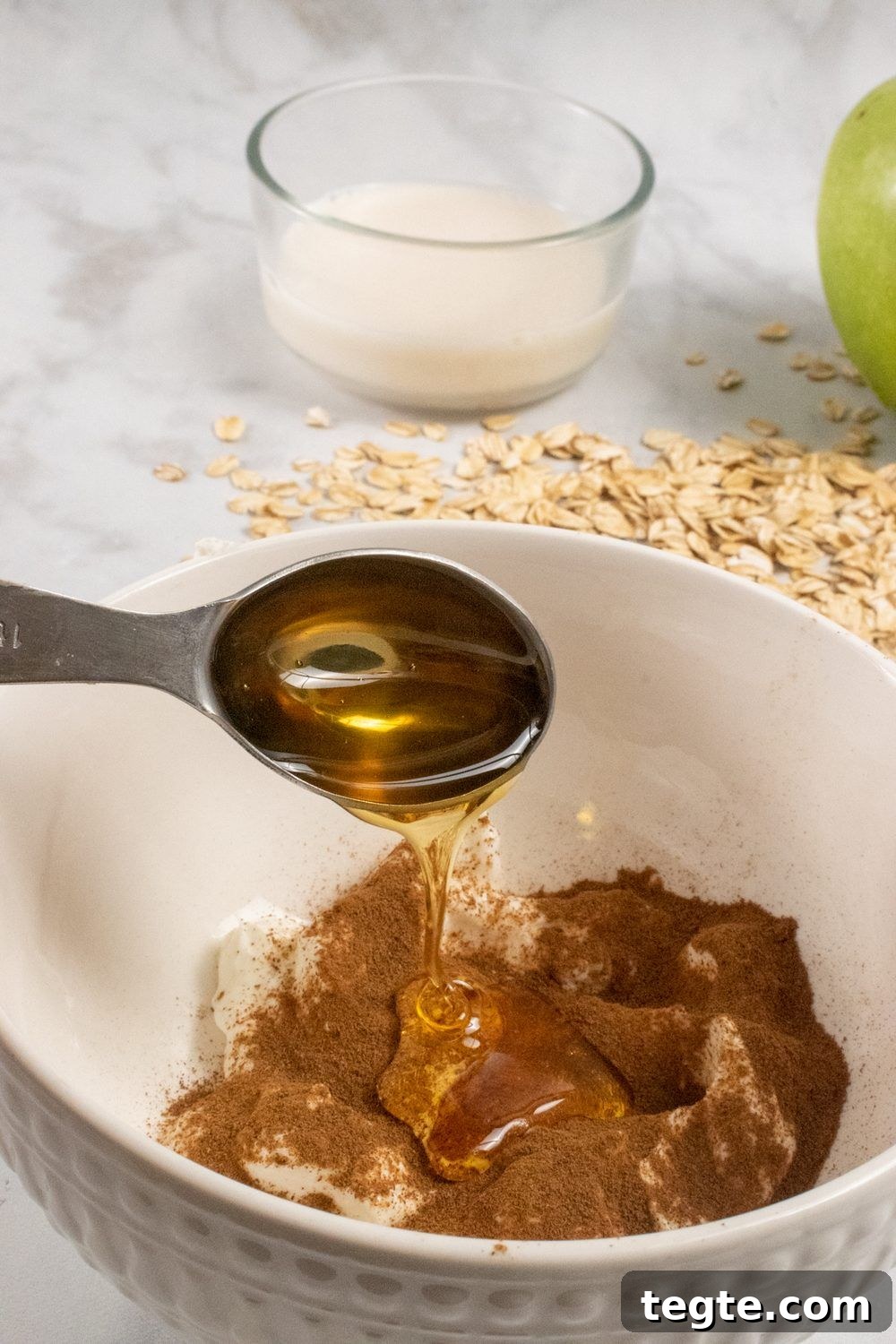Apple Cinnamon Overnight Oats with Yogurt and Fresh Apples 6 Apple-overnight-oats-honey being drizzled over it