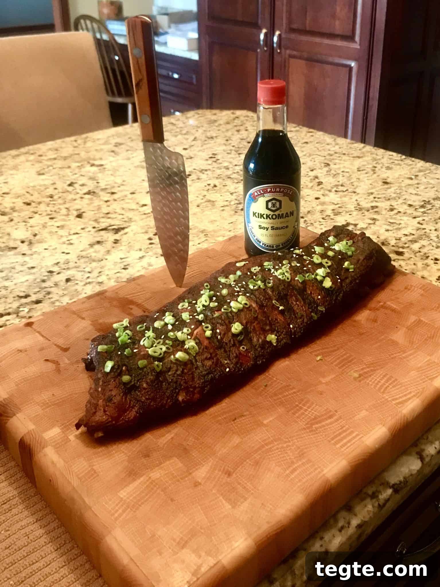 Spicy Asian Ribs on wooden cutting board with soy sauce and knife in background