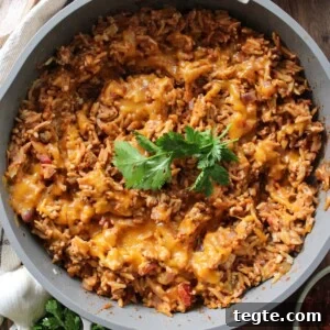 Cheesy Taco Rice Skillet — One-Pan Weeknight Dinner 8 Cheesy taco rice in a skillet garnished with cilantro.