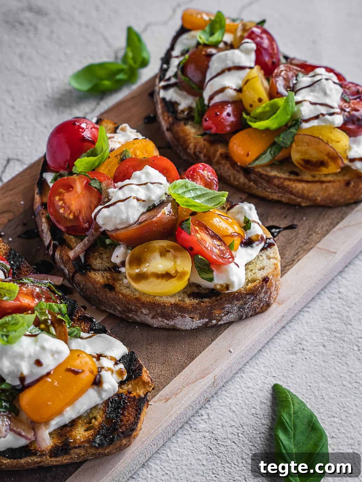 Creamy Burrata Bruschetta with Heirloom Tomatoes and Basil 8 Burrata bruschetta toasts with cherry tomatoes and cheese.