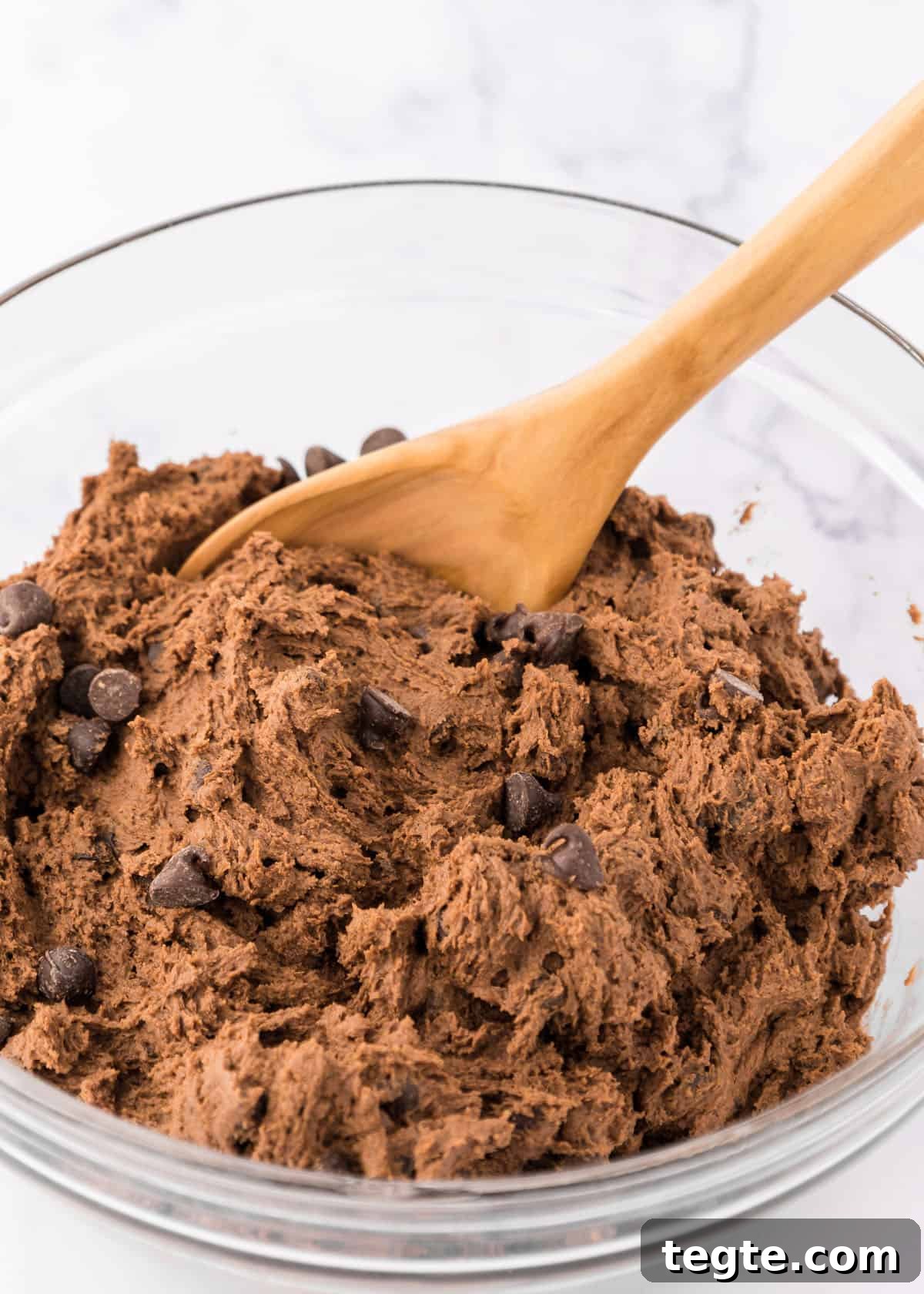Ultimate Double Chocolate Cookies Recipe: Moist, Fudgy Bites 5 Double chocolate chip cookie dough in a bowl with a wooden spoon.