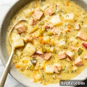 a bowl of dill pickle soup with a spoon