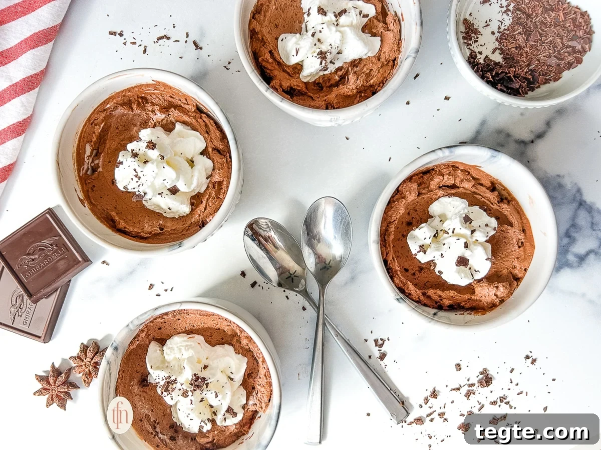 Decadent 3-Ingredient Chocolate Mousse Recipe 8 Four small bowls filled with chocolate mousse on a white surface.