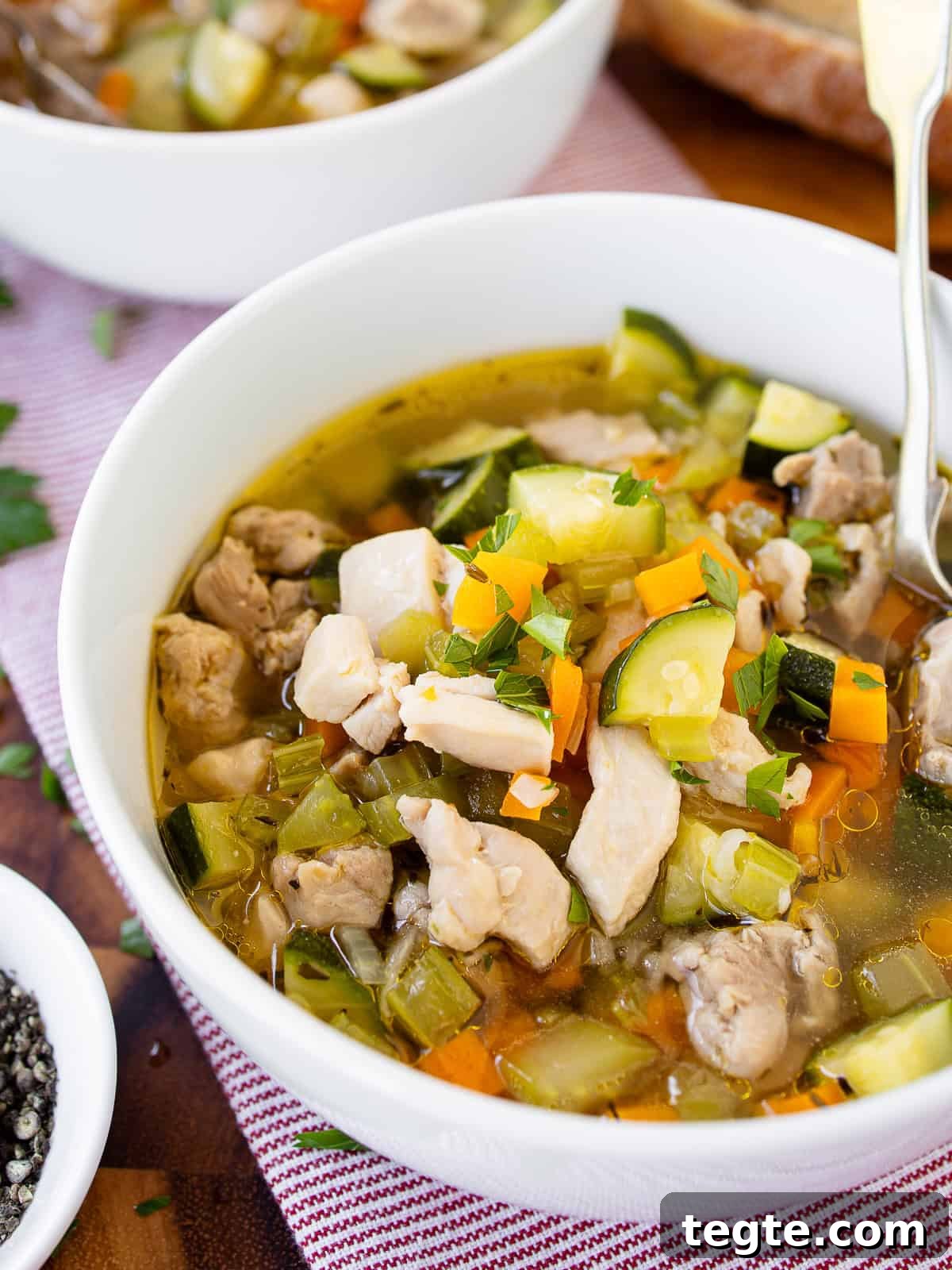 Hearty Homemade Chicken and Vegetable Soup Recipe 2 A bowl of chicken vegetable soup with bread.