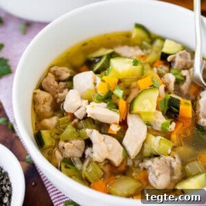 Hearty Homemade Chicken and Vegetable Soup Recipe 10 A bowl of chicken vegetable soup with bread.