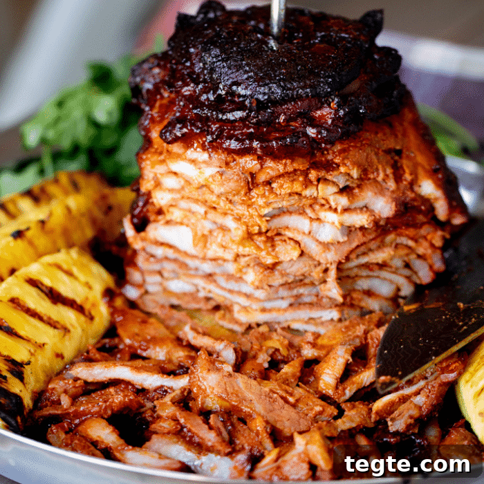 14 Pepper Recipes to Turn Up Flavor on Your Grill 11 Al pastor on a round metal dish next to pineapple spears.