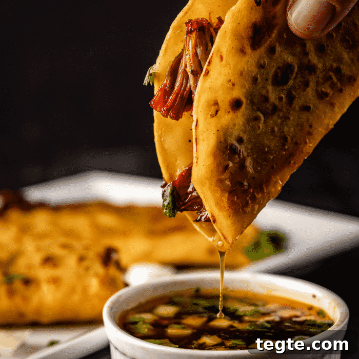 14 Pepper Recipes to Turn Up Flavor on Your Grill 12 Smoked birria taco being dipped in consomme.