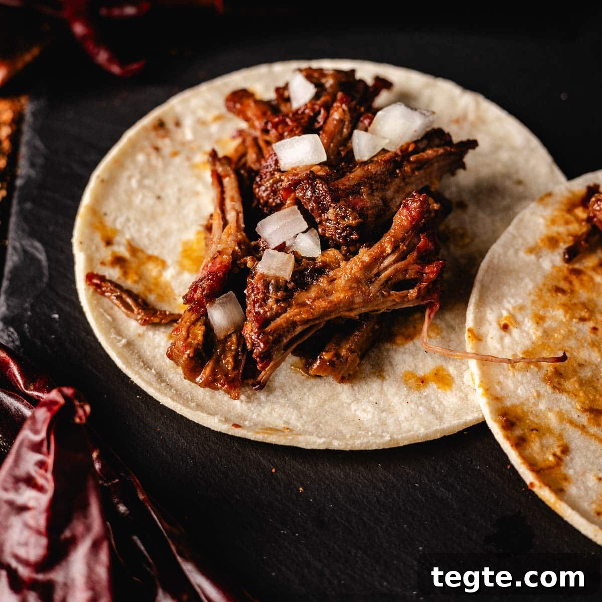 14 Pepper Recipes to Turn Up Flavor on Your Grill 13 Smoky barbaoca taco on black serving platter.