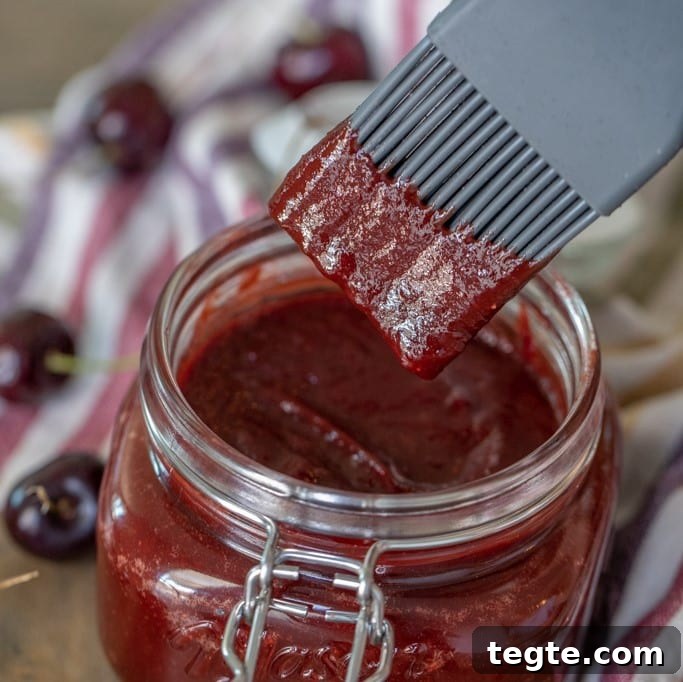 14 Pepper Recipes to Turn Up Flavor on Your Grill 9 Cherry chipotle bbq sauce in a glass jar with a basting brush dipping into the sauce.