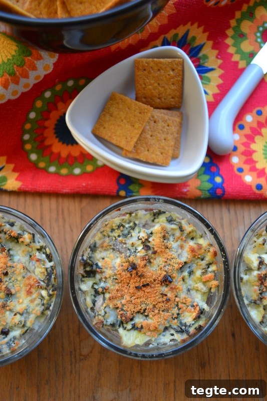 Spinach Artichoke Dip Individual Appetizers on table with wheat chips.